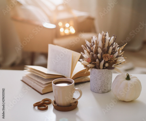 Autumn still life. Coffee cup, flowers, book and pumpkin. Hygge lifestyle, cozy autumn mood. Flat lay, Happy thanksgiving 