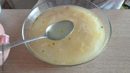 woman eating chicken soup from a transparent plate. photo