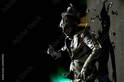 Side view of professional mime dressed like bronze statue