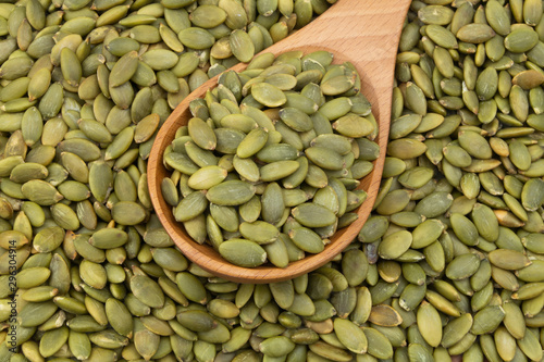 Pumpkin seeds and wooden spoon, top view