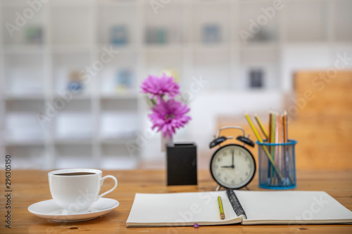 office table desk. Workspace with white  coffee cup , blank note book, colck and office supplies background. photo