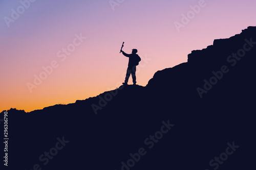 photo in a dark key on the mountain during sunset a man takes a selfie on the mountain