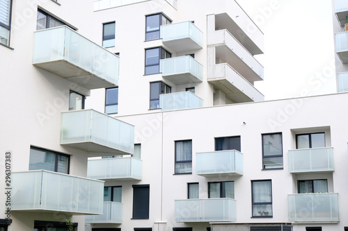 Exterior of a modern apartment buildings with balcony and white walls.