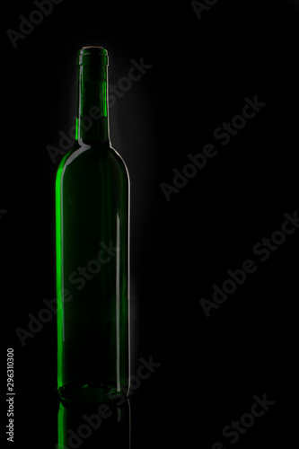 Wine green bottle silhouette. Closeup of an opening of a wine bottle with cork in front of black background with text field.