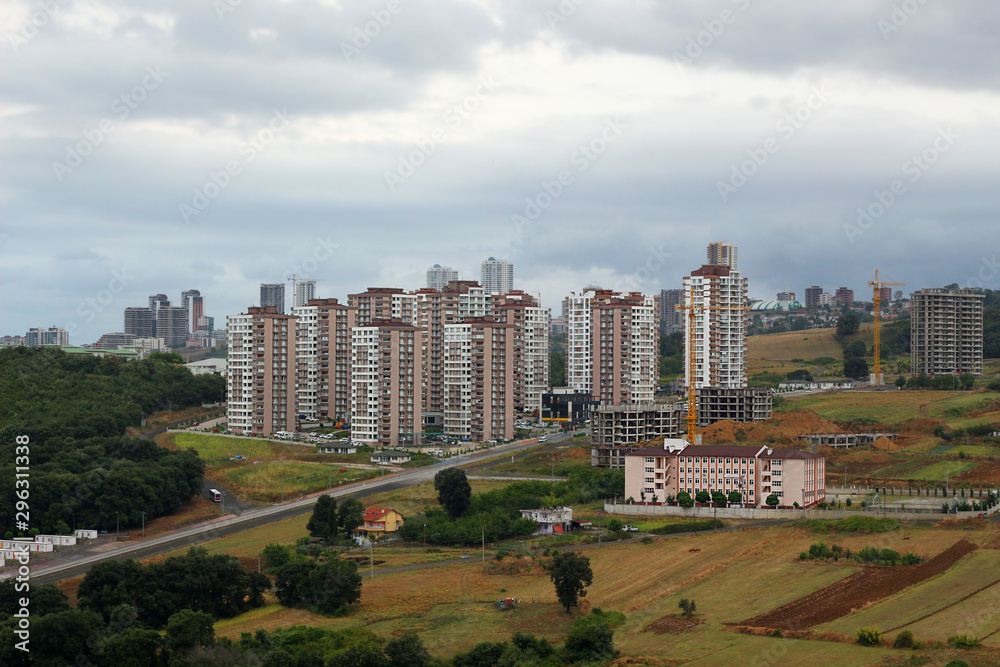 Obraz premium Photo of a combination of nature and residential town with tower building in the beautiful city of Samson in Turkey with cloudy sky