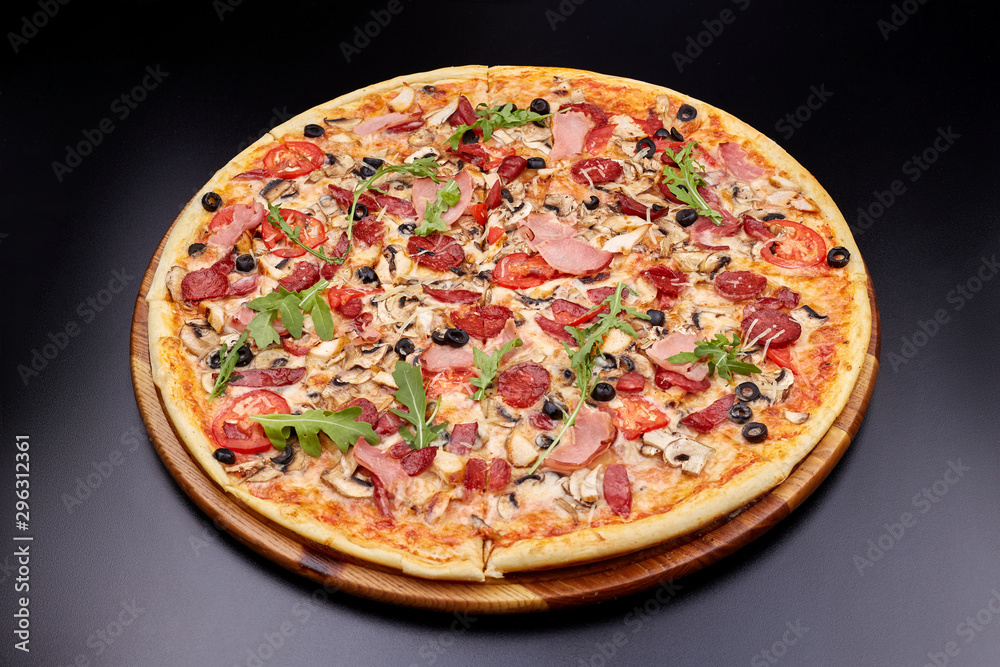 Fresh pizza Campania on wooden cutting board. isolated on dark background. Fresh pizza Campania on wooden cutting board. isolated on dark background.