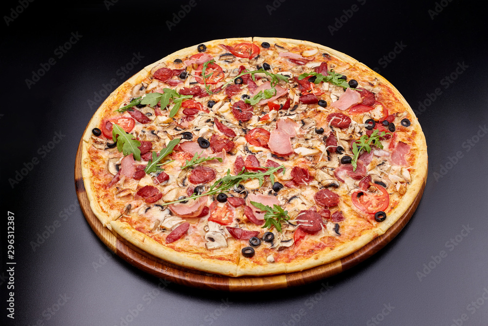 Fresh pizza Campania on wooden cutting board. isolated on dark background.