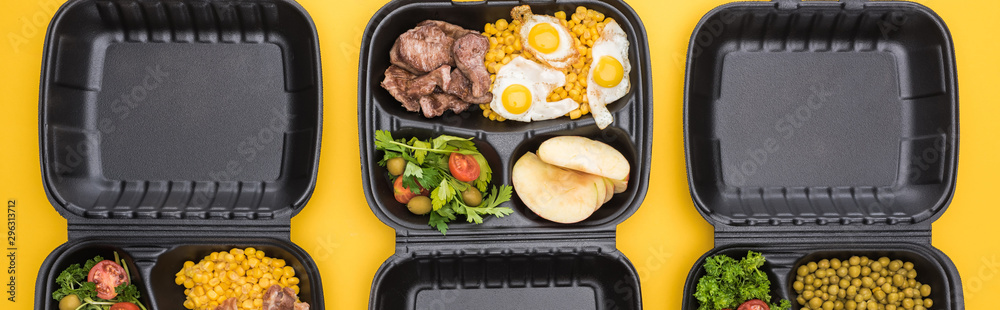 panoramic shot of eco packages with vegetables, apples, meat, fried eggs and salads isolated on yellow panoramic shot of eco packages with vegetables, apples, meat, fried eggs and salads isolated on yellow