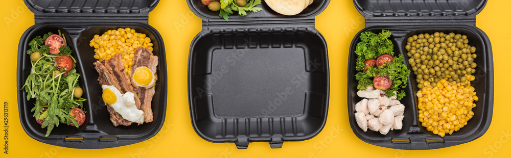 panoramic shot of eco packages with vegetables, meat, fried eggs and salads isolated on yellow
