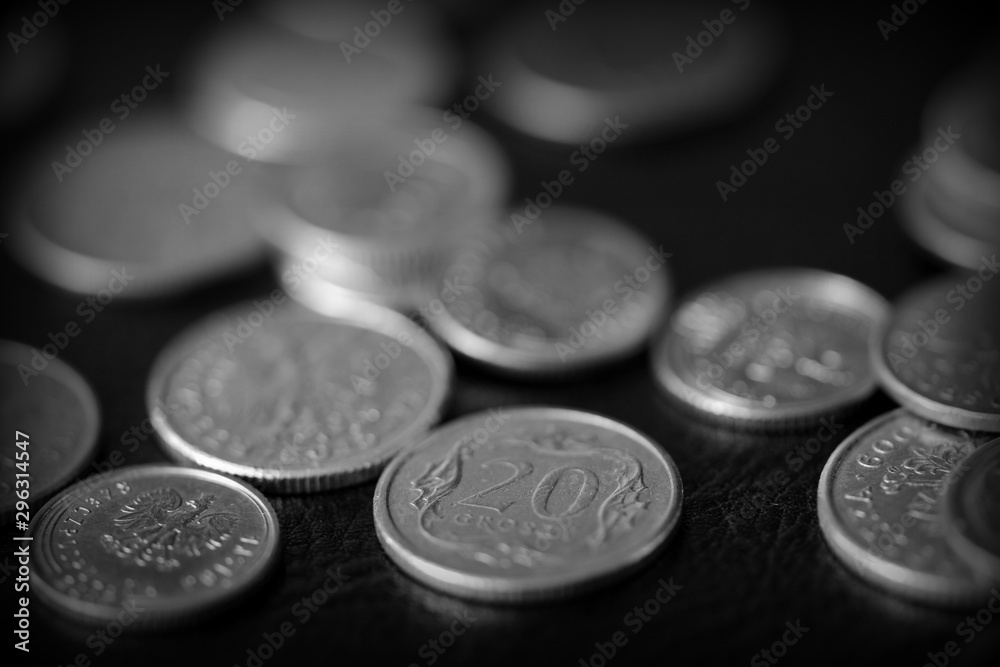Polish coins scattered on a dark background close up, black and white Polish coins scattered on a dark background close up, black and white