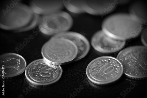 Polish coins scattered on a dark background close up, black and white