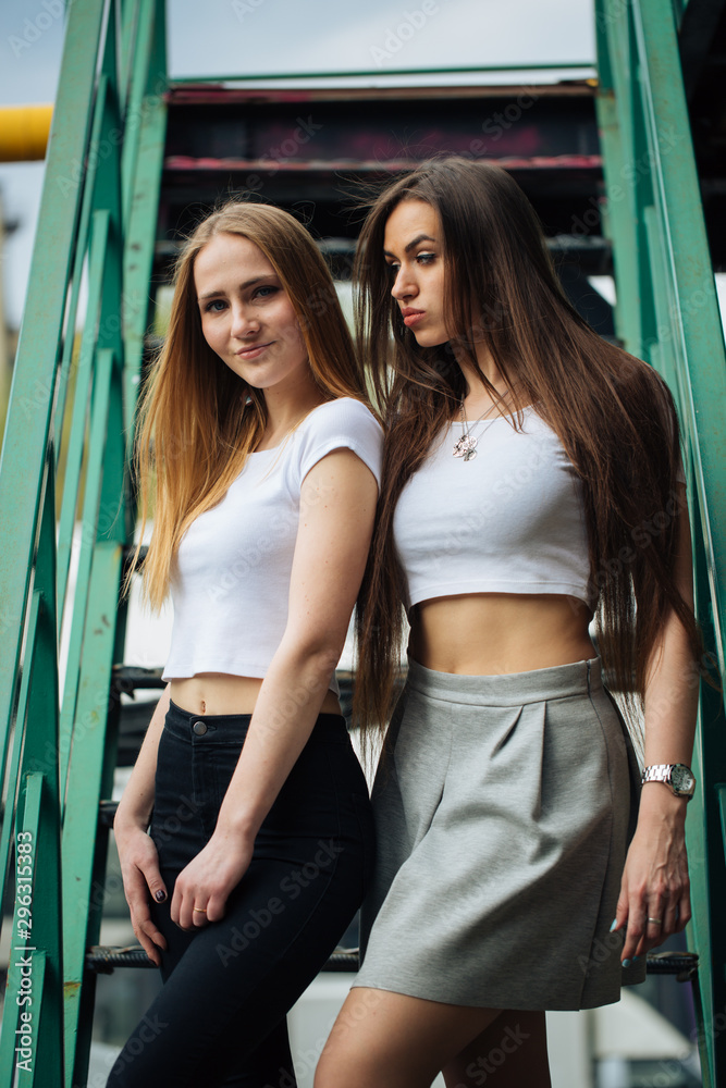 two very cute young girls posing as top models on a street in Europe on  vacation,sisters actively posing on a sunny summer day,very happy and  joyful people Photos | Adobe Stock