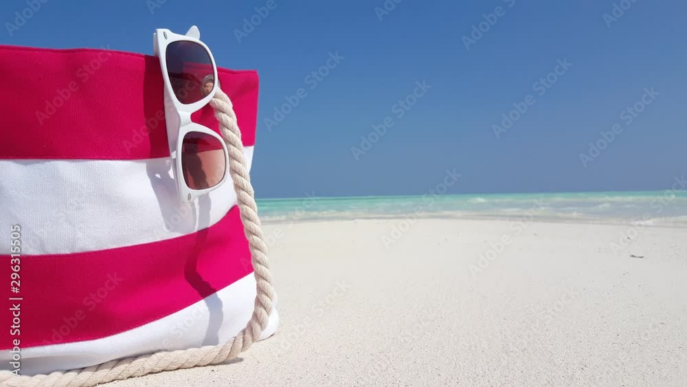 Summer Accessories bag on a beach in Thailand, with sunglasses hanging out Summer Accessories bag on a beach in Thailand, with sunglasses hanging out