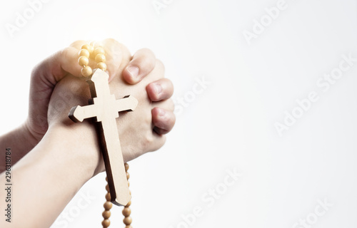 Close up of cross in hands while holding praying God. White background with copy space. isolated.