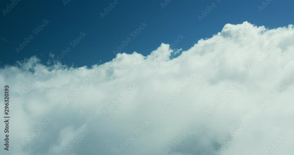 Aerial drone view flying forward through a sunny cloudscape mid day with blue skies, travel airlines freedom concept, cloudscape background