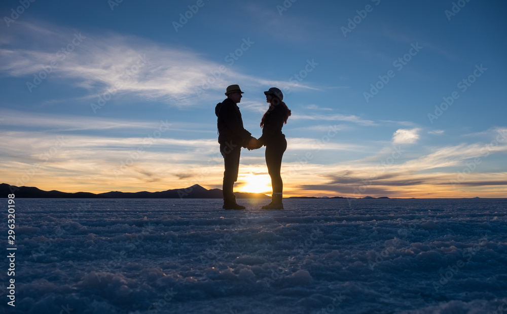 silueta de una pareja tomada de las manos en un atardecer con cielo azul