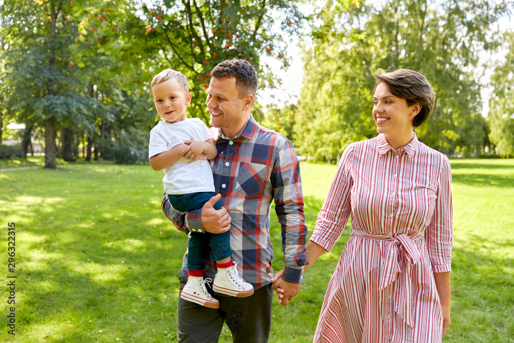 family, leisure and people concept - happy mother, father and little son at summer park family, leisure and people concept - happy mother, father and little son at summer park