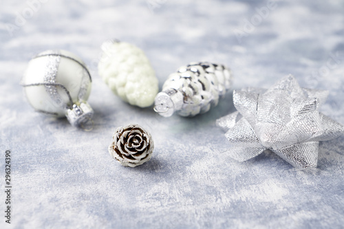 Pine cone and silver Christmas baubles. Christmas decoration on bright wooden background. Close up. 