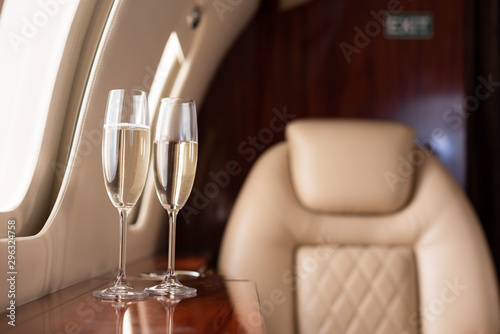 selective focus of interior of plane with champagne glasses for trip