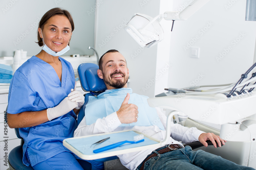 Fototapeta premium Man is satisfied in chair after treatment in dental office