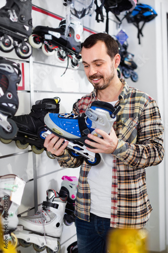 Guy deciding on new roller-skates in sports store
