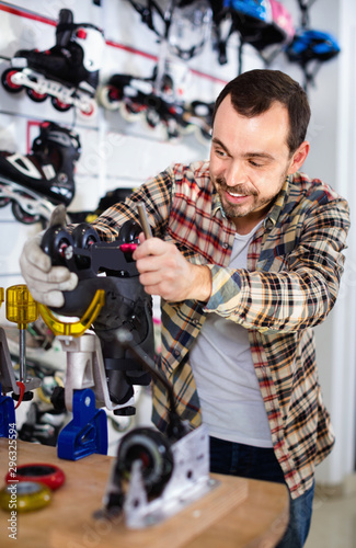 Male repairer fixing roller-skates in sports store