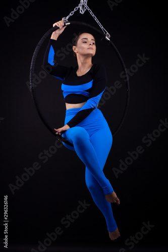 A female gymnast performing exercises on an air ring (hoop) © Oleksii