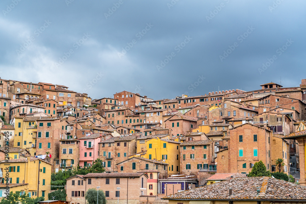 Colorful Buildings in Siena Italy with dark cloudy sky
