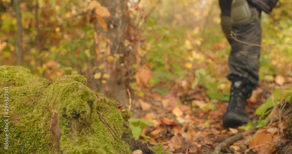 Mans legs dressed in military camouflage clothes and boots stepping and walking at around green landscape beautiful forest location, Sunny day travel concept Mans legs dressed in military camouflage clothes and boots stepping and walking at around green landscape beautiful forest location, Sunny day travel concept