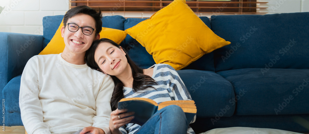 Obraz premium sweet lovey asian family couple sit talk good conversation on sofa in living room house background