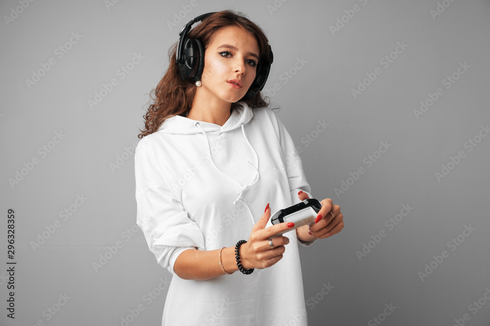 Young pretty woman playing with console joystick over a gray background Young pretty woman playing with console joystick over a gray background