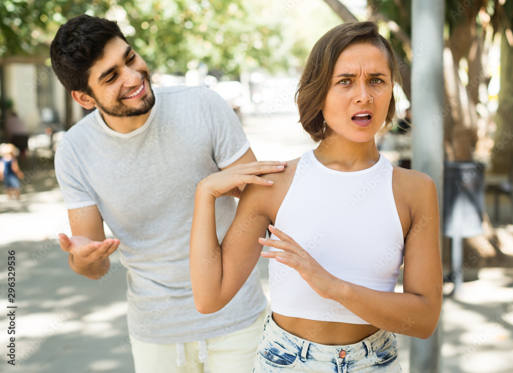 portrait of young male and female talking emotional at the street