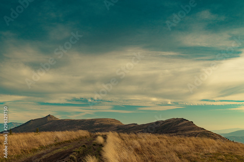 gorgeous dramatic highland landscape wallpaper poster photography of mountain ridge on cloudy evening sky background with empty copy space for text 