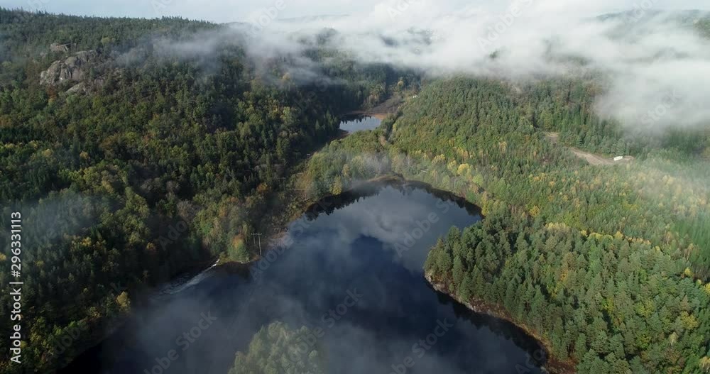Aerial view of lake in mountains. Clouds are reflected in water.