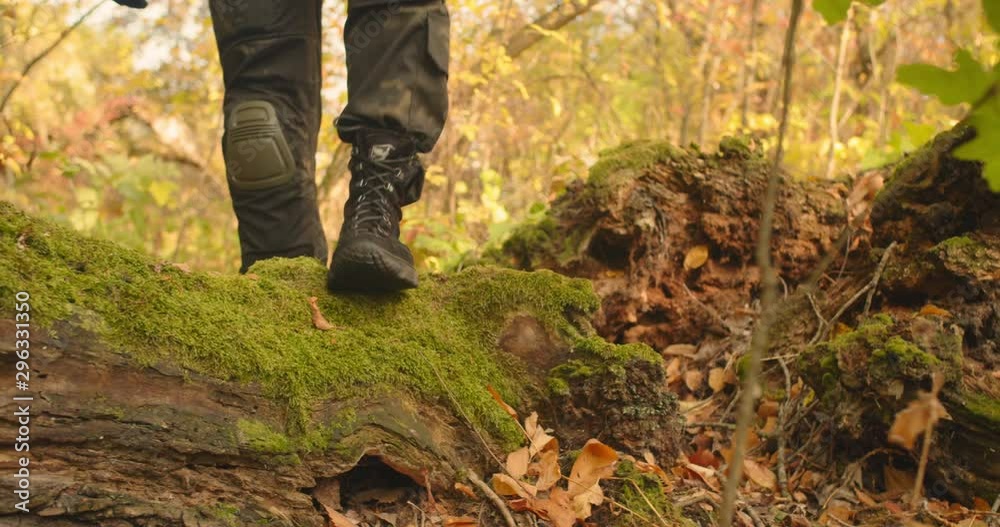 Mans legs dressed in military camouflage clothes and boots stepping and walking at around green landscape beautiful forest location, Sunny day travel concept Mans legs dressed in military camouflage clothes and boots stepping and walking at around green landscape beautiful forest location, Sunny day travel concept
