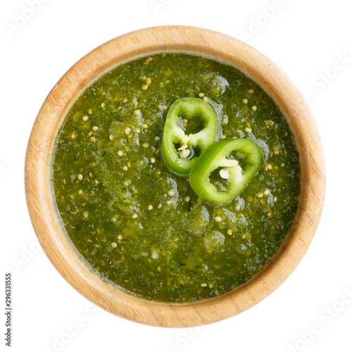 Tomatillo salsa verde. Bowl of spicy green sauce isolated on white table, mexican cuisine. Top view.