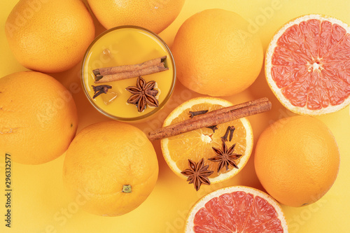 Fototapeta Naklejka Na Ścianę i Meble -  Fresh orange cinnamon star anise clove spice juice in glass on white yellow background