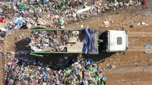 Loaded Garbage Truck unloading at a Municipal landfill, Top down aerial footage.