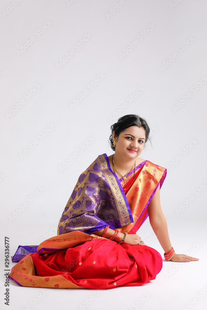 Young Indian woman wearing sari and trying jewelry 