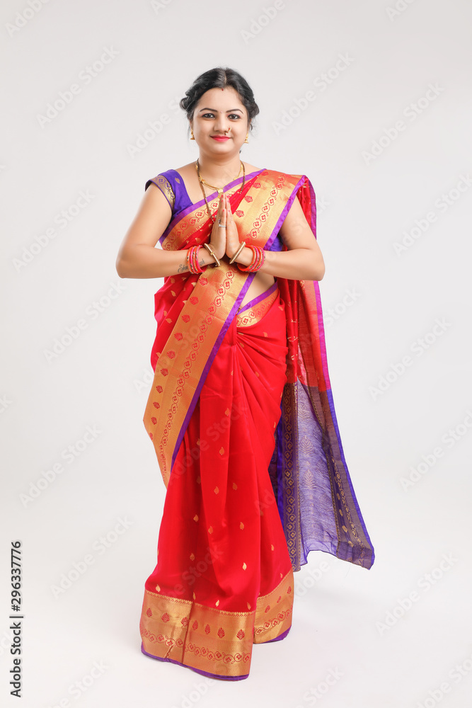  young Indian woman wearing  Sari  and showing a welcome gestures, isolated on white background