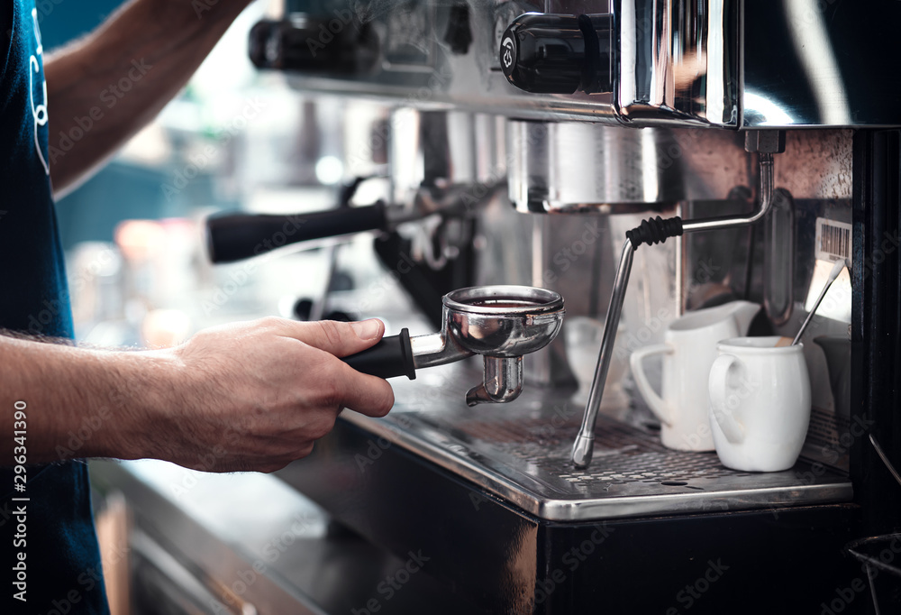 Close up of barista hands preparing cappuccino.