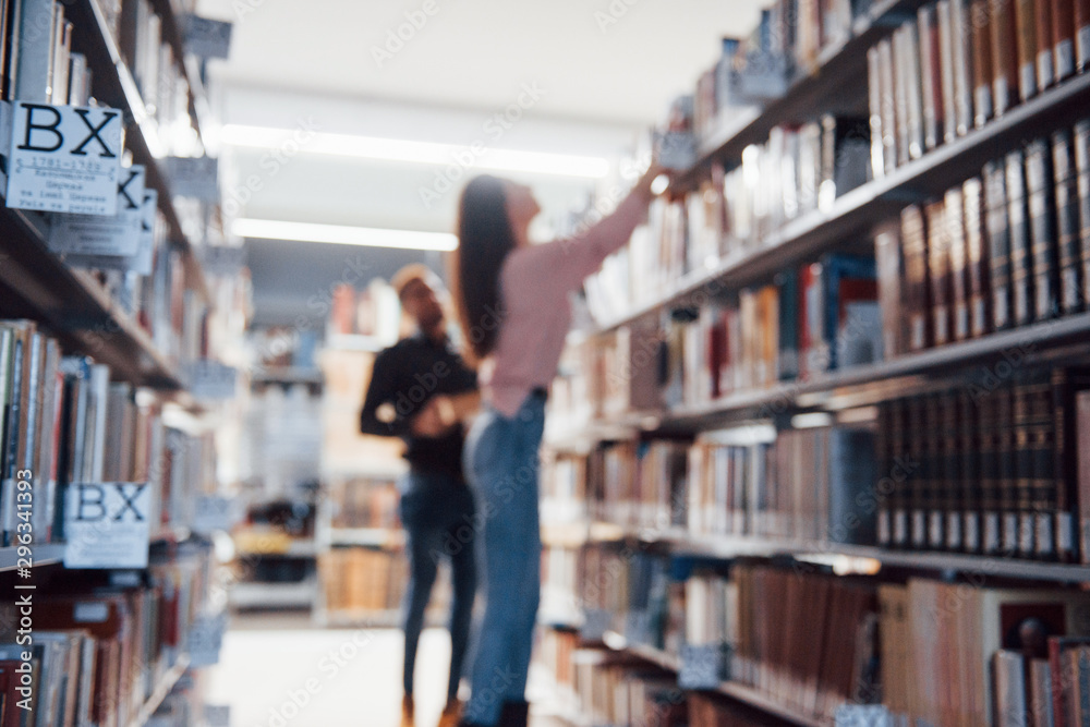 Blurred photo. Multiracial students in the library searching for the information together Blurred photo. Multiracial students in the library searching for the information together