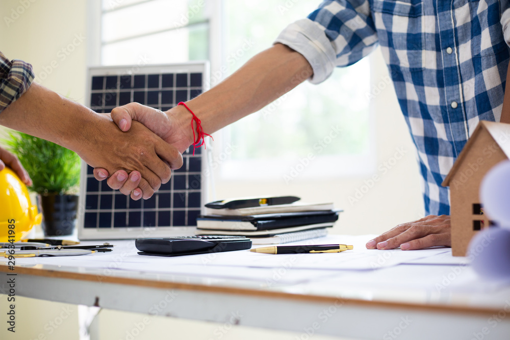 Team Engineers are shaking hand solar panel Business for home construction designs to bring them to prospective customers.concept Team Engineers are shaking hand solar panel Business for home construction designs to bring them to prospective customers.concept