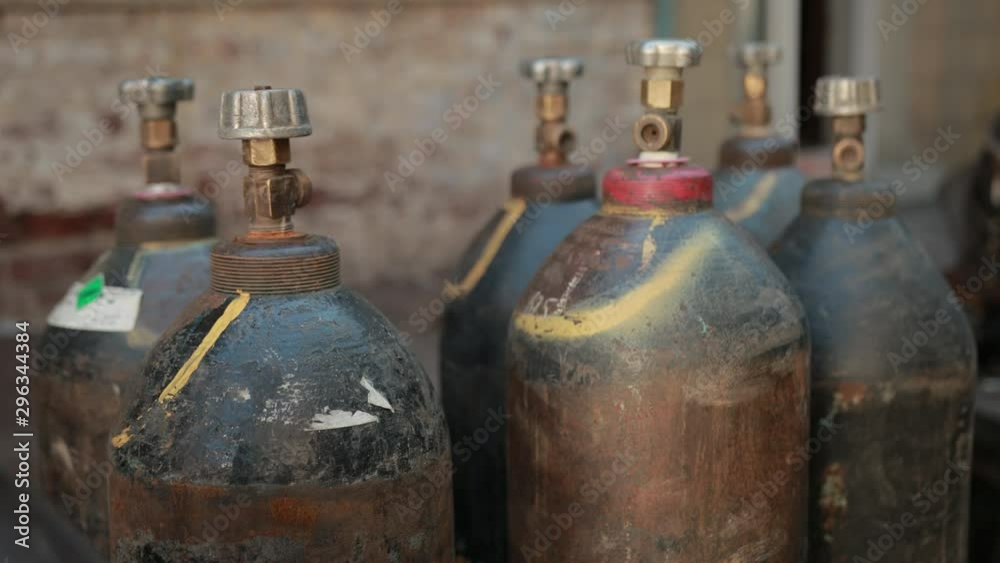 on street near old buildings, plant, are worth many gas cylinders, slow motion, close up on street near old buildings, plant, are worth many gas cylinders, slow motion, close up