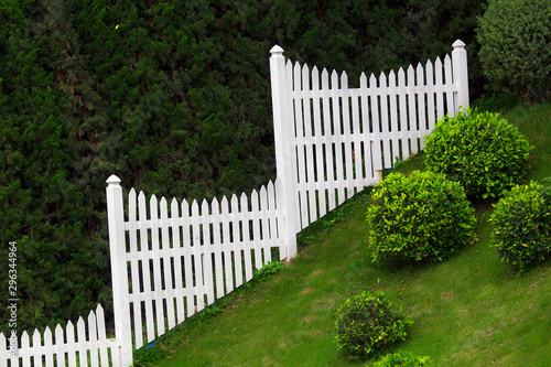 green garden on the hill with white fence