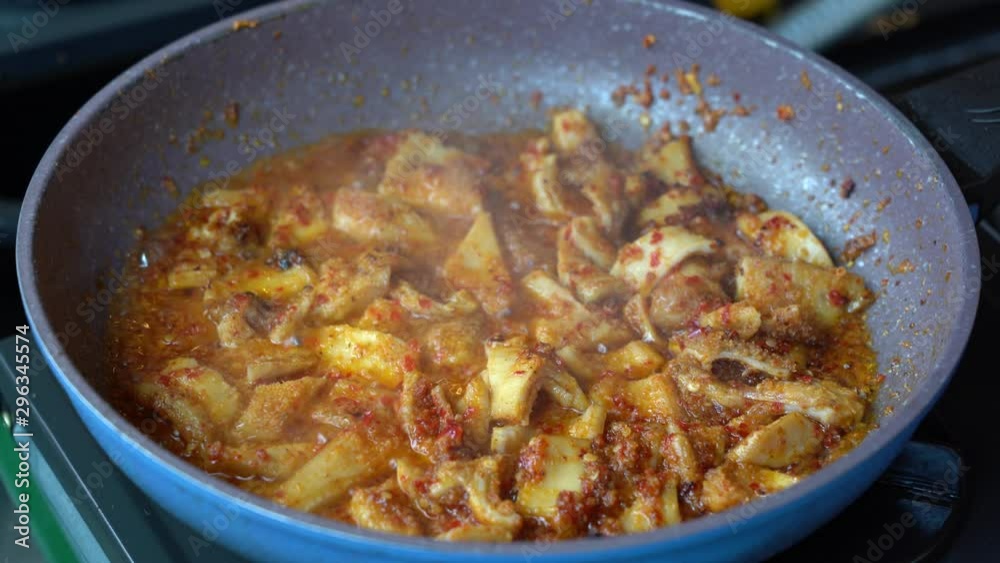 Frying pan with onion, beef stomach, red pepper and sauce, close up. Indonesia. Indonesian cuisine, spicy beef stomach meet and sauce garnish with lemongrass leaf and red chili. Cooking food Frying pan with onion, beef stomach, red pepper and sauce, close up. Indonesia. Indonesian cuisine, spicy beef stomach meet and sauce garnish with lemongrass leaf and red chili. Cooking food
