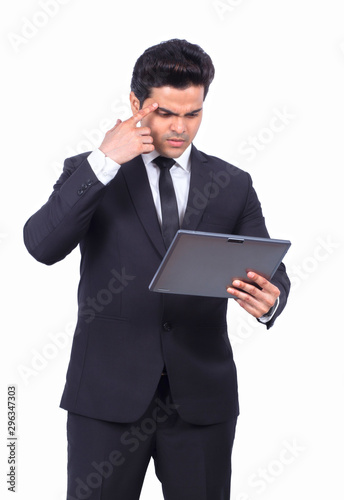 Serious young businessman using digital tablet on white background