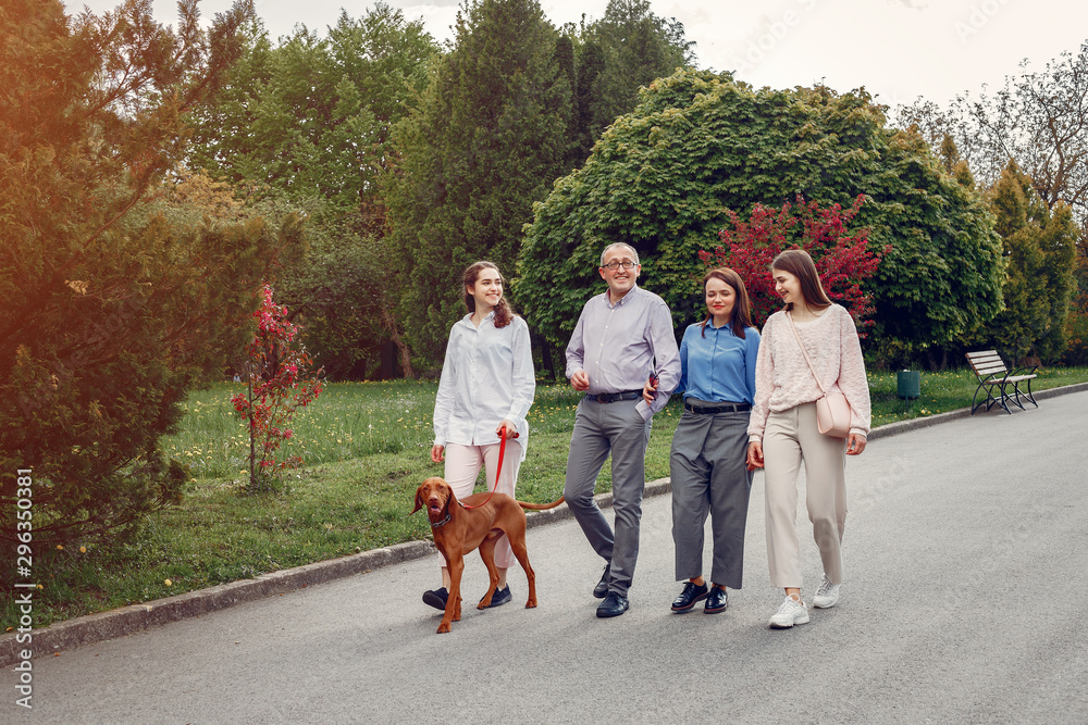 Family in a summer park. People walking with a dog. Parents with a two daughters Family in a summer park. People walking with a dog. Parents with a two daughters