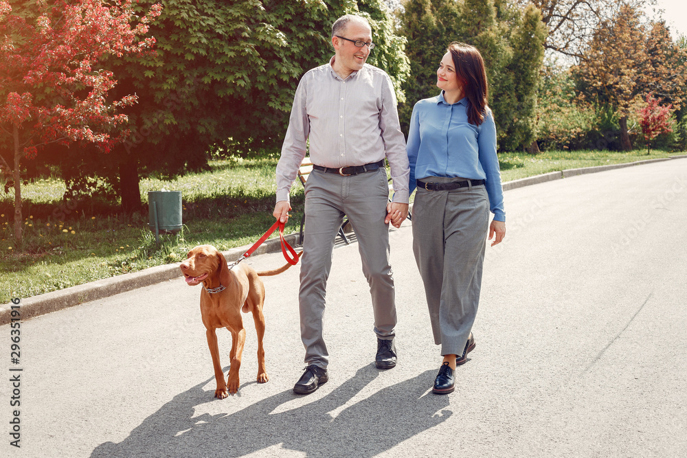 Couple in a forest. Adult pair with cute dogs. Lady in a blue shirt Couple in a forest. Adult pair with cute dogs. Lady in a blue shirt
