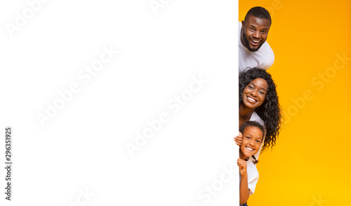 Parents And Daughter Peeking Out Of Blank White Board For Advertisement